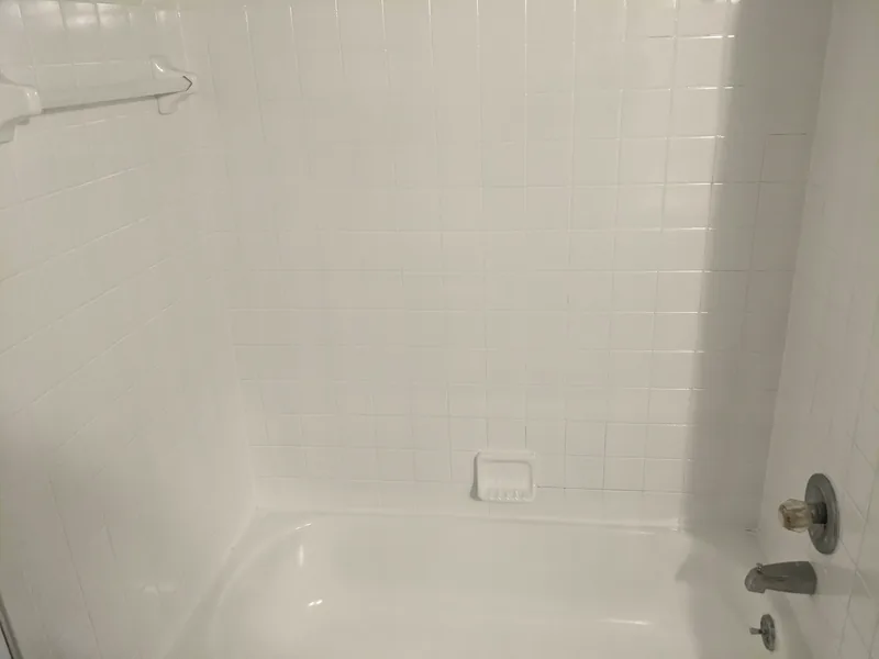 A refinished white shower surround.