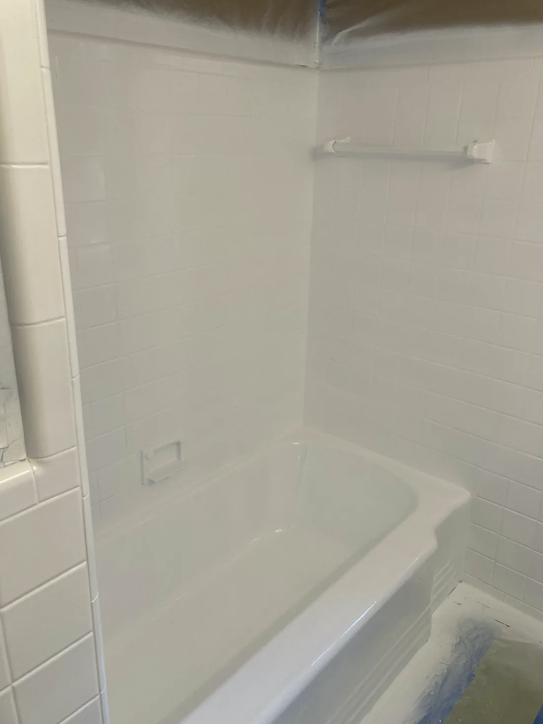 A refinished bathtub and tile surround, sprayed a clean white.
